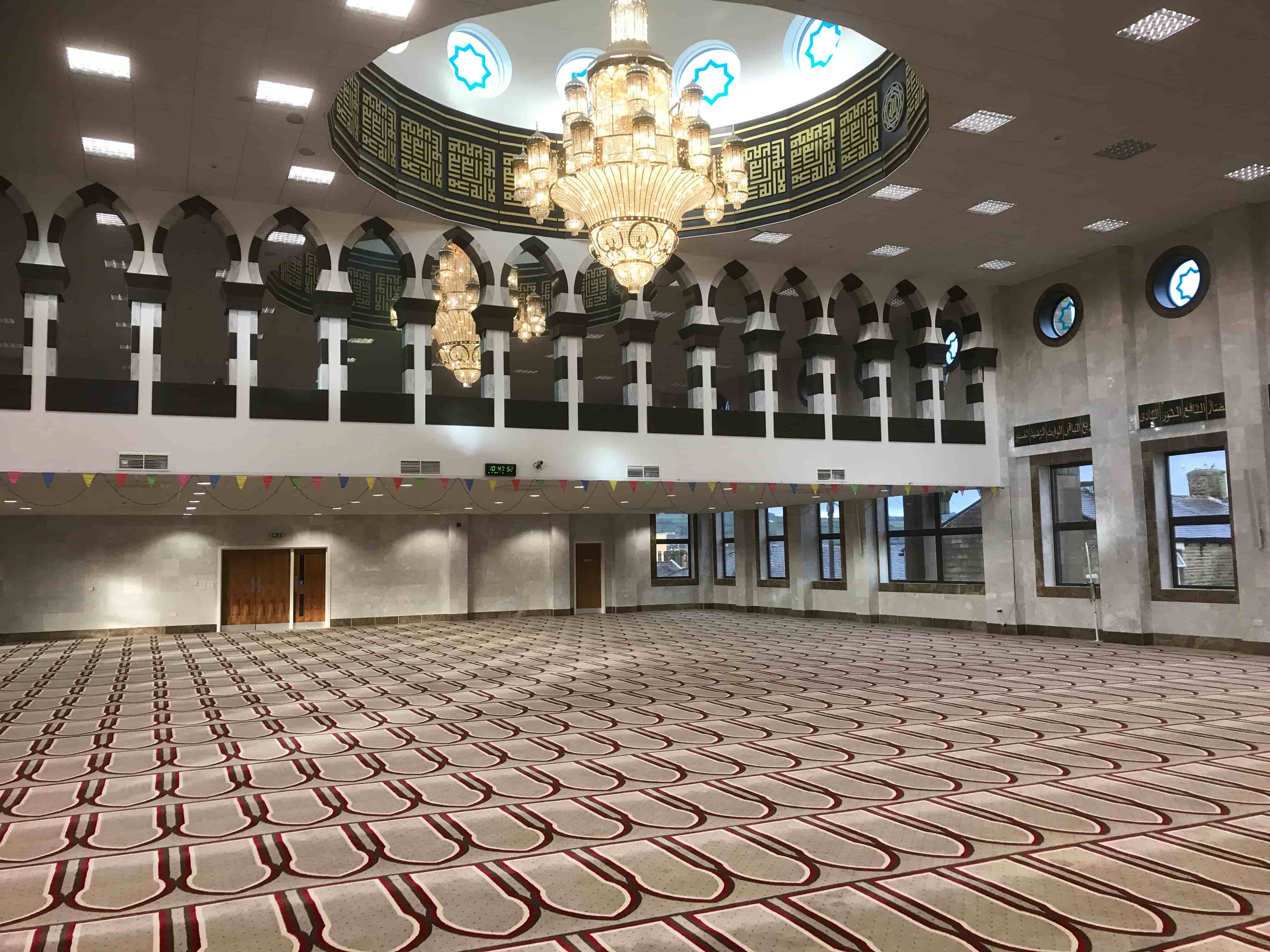 Modern mosque prayer hall fitted by Opus AV &mdash; chandelier, dome and full-coverage PA